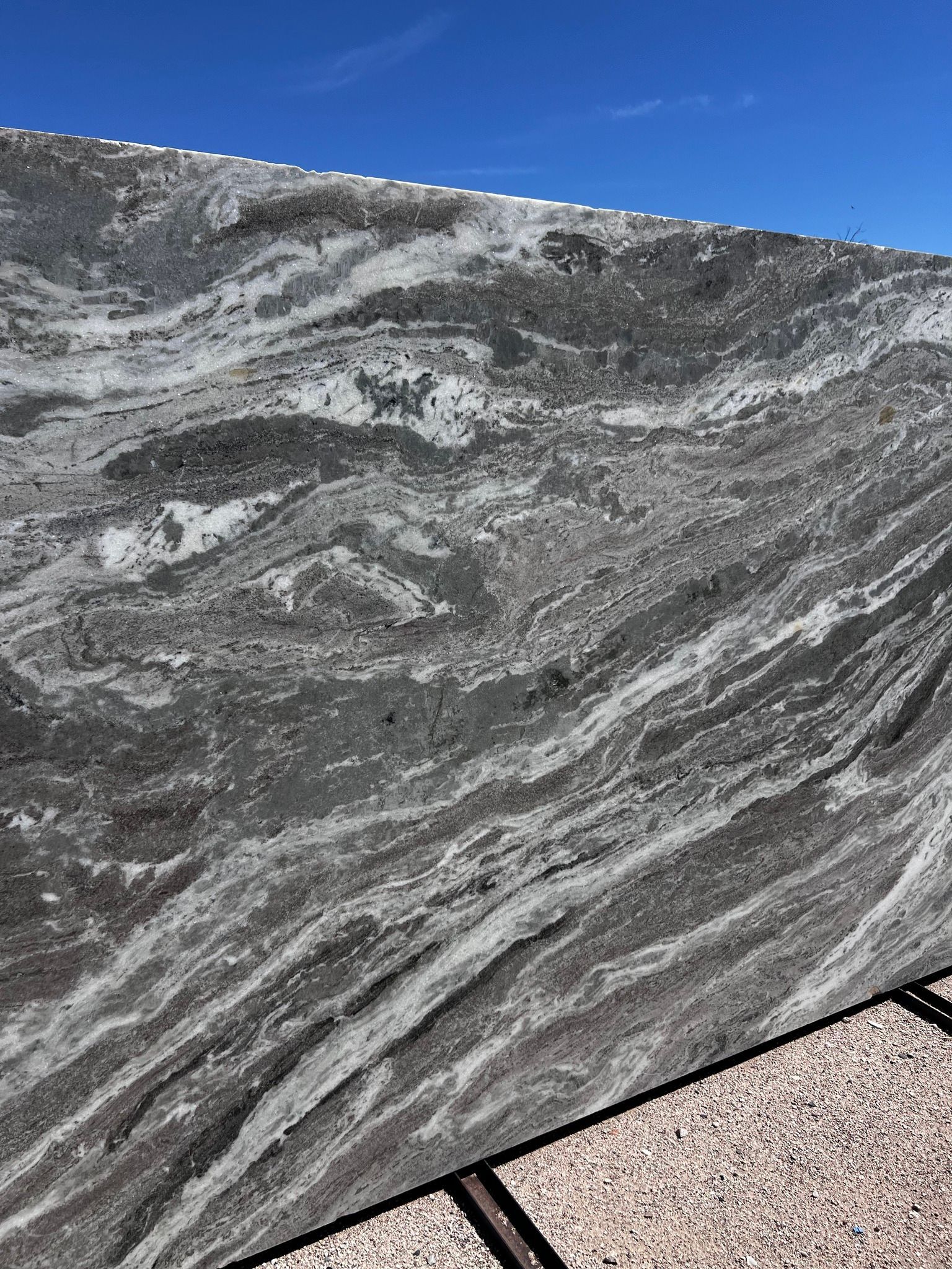 A close up of a marble slab with a blue sky in the background.
