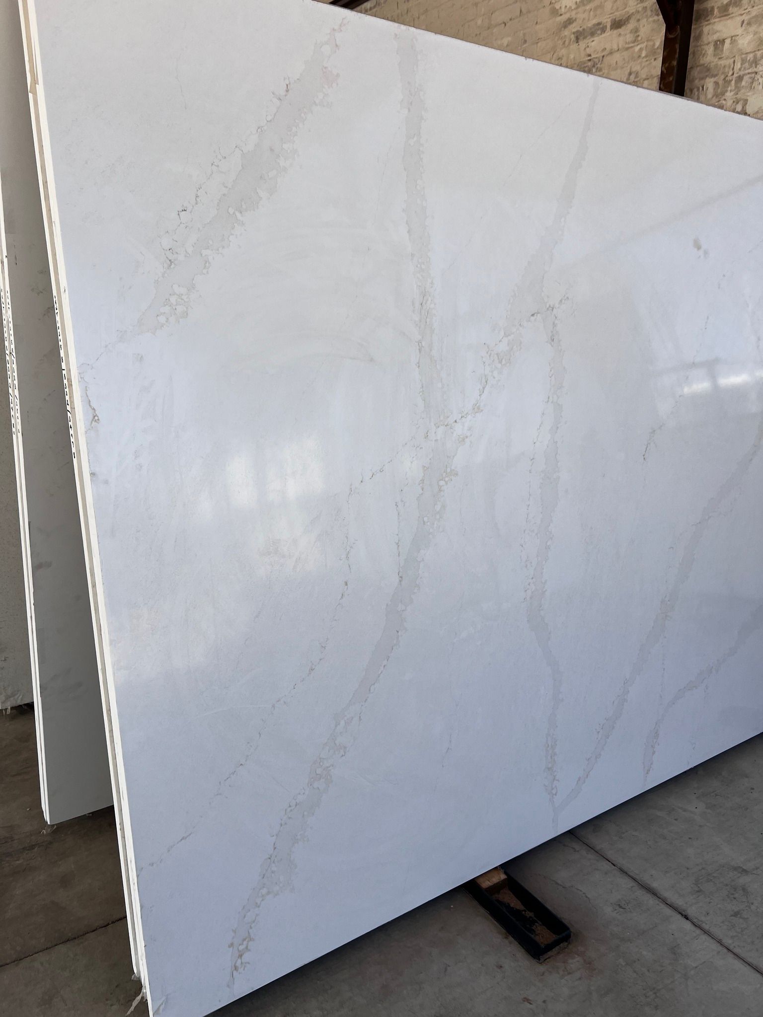 A large white slab of quartz is sitting on top of a concrete floor.