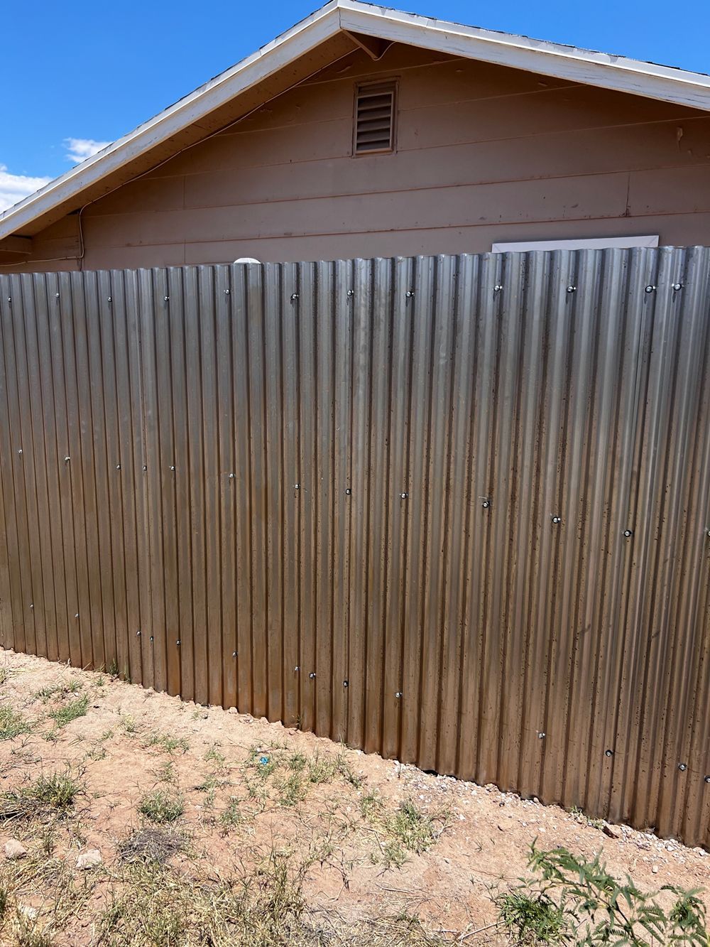 A wooden fence is sitting in front of a house.