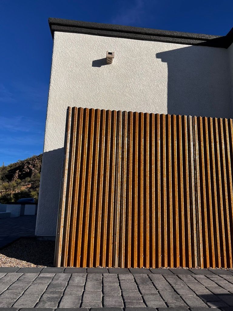 A wooden fence is in front of a white building.