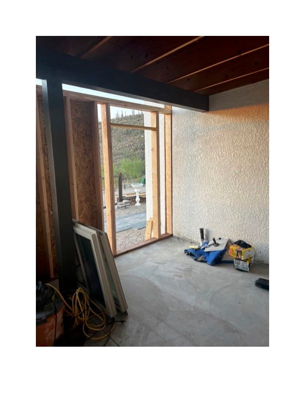 A room with a large window and a wooden ceiling.