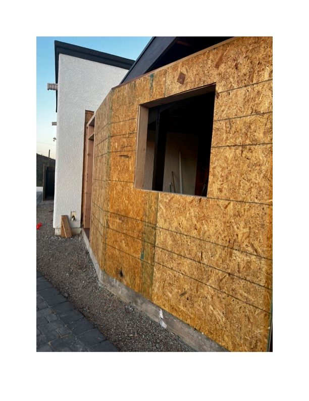 A wooden wall with a window in it is being built.