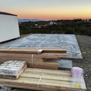A pile of wood is sitting on top of a concrete floor.