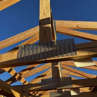 A close up of a wooden structure with a blue sky in the background.
