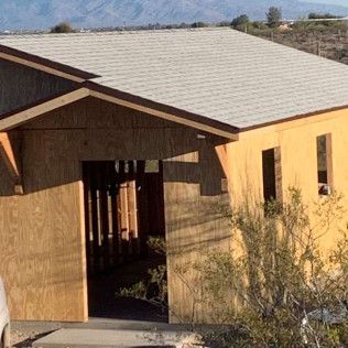 A house is being built in the desert with a white roof.