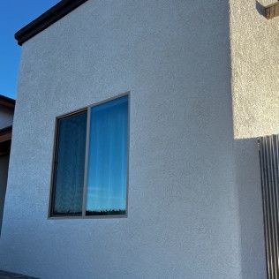 A white building with a large window on the side of it.