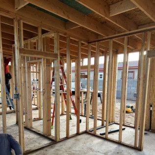 A man is standing in a room with a lot of wooden beams.