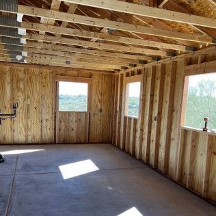 A room with wooden walls and windows under construction.