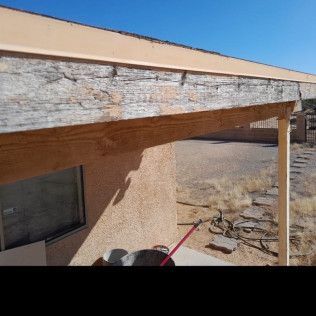 A person is cleaning the roof of a house with a broom.