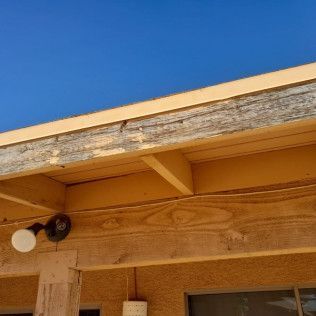 A close up of a wooden roof with a blue sky in the background.