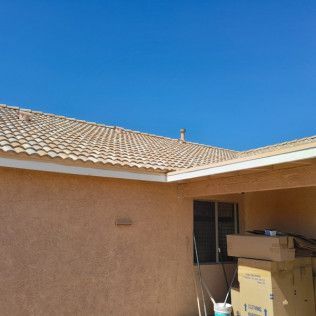 A house with a tiled roof and a blue sky in the background.