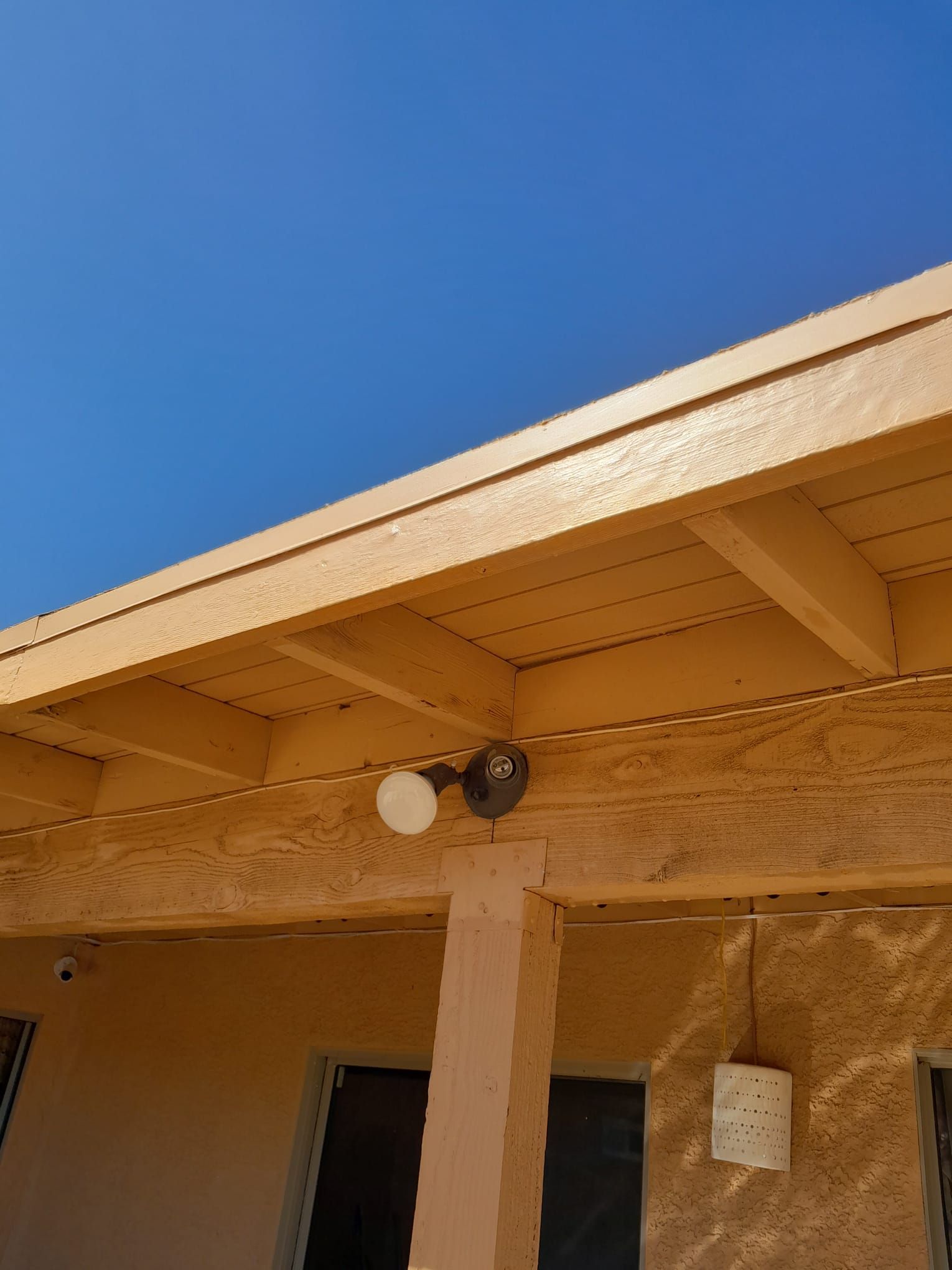 A roof with a light on it and a blue sky in the background