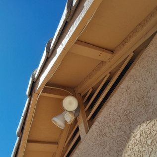 A roof with a light on it and a blue sky in the background.