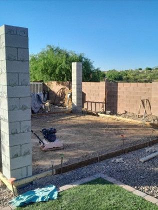 A brick wall is being built in a backyard.