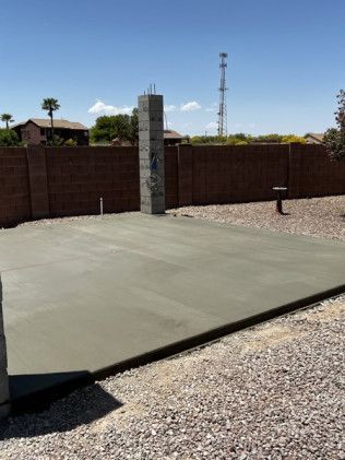 A concrete driveway with a brick fence in the background