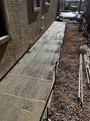 A sidewalk is being built in front of a house.