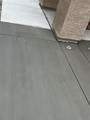 A close up of a concrete floor with a ramp in the background.