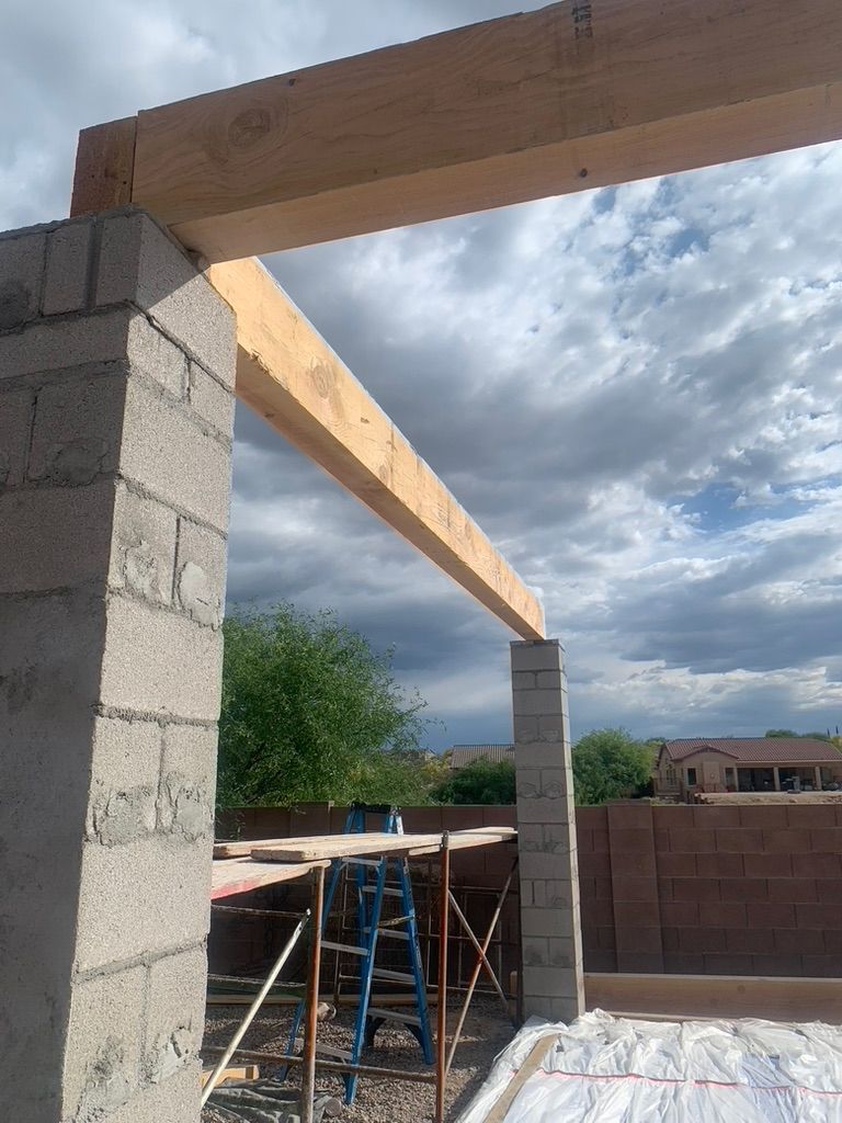 A wooden beam is being built on top of a brick wall.