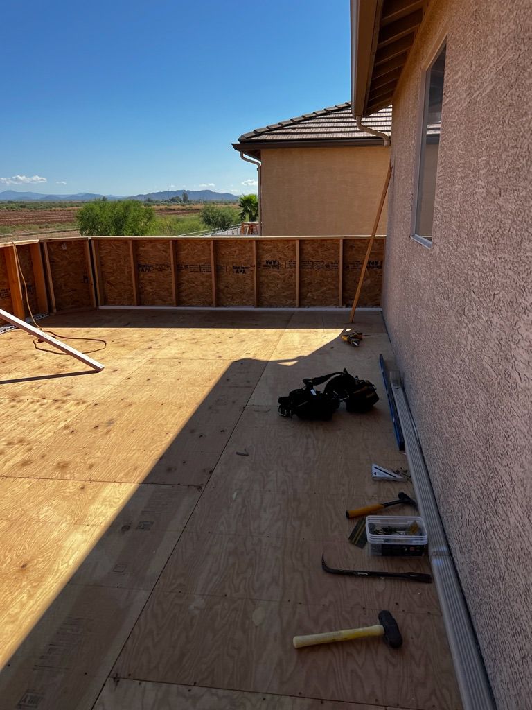 A hammer is laying on a wooden floor in front of a house