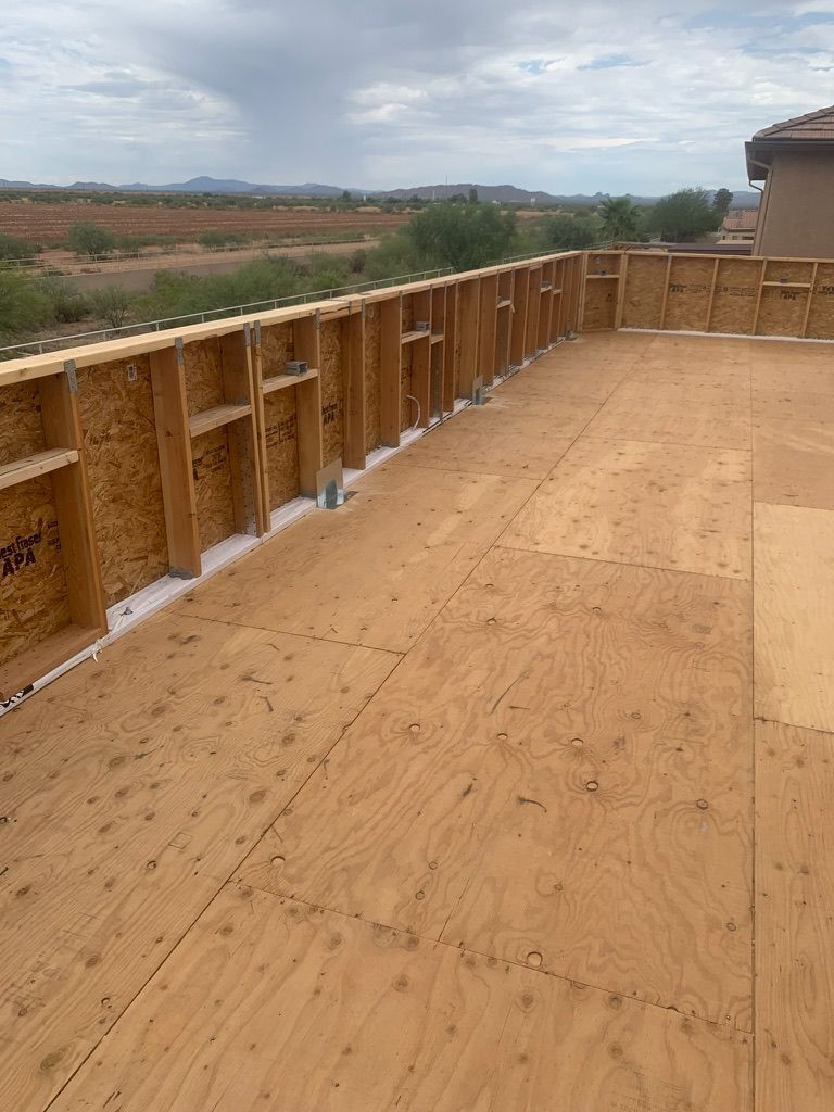 A large piece of plywood is sitting on top of a wooden deck.