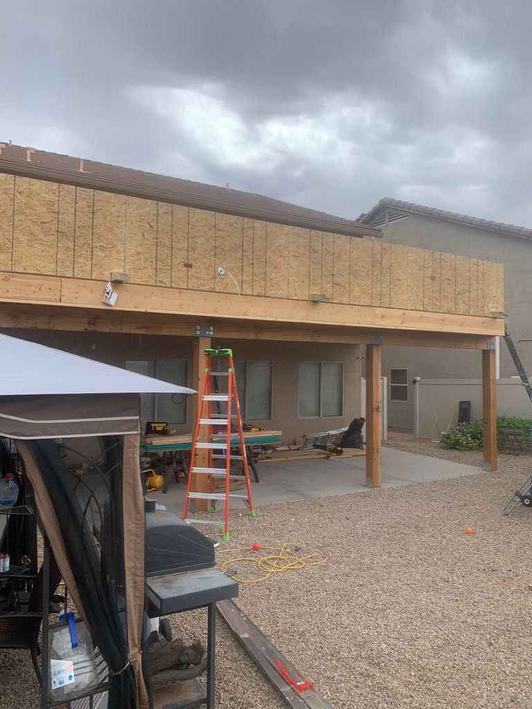 A wooden deck is being built in the backyard of a house.