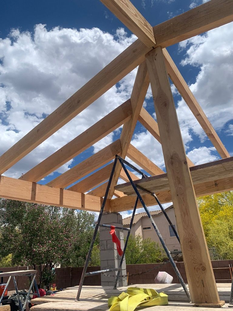 A wooden structure is being built on a sunny day.