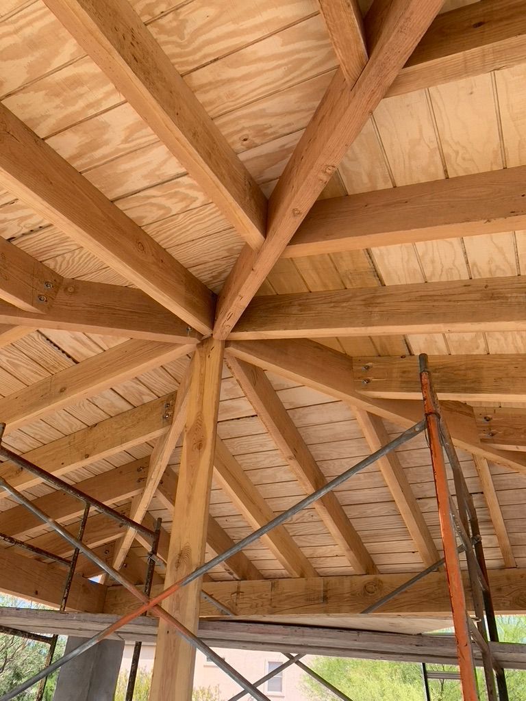 The ceiling of a building under construction with wooden beams and scaffolding.