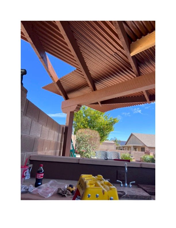 A coca cola bottle is sitting on a table under a wooden roof.