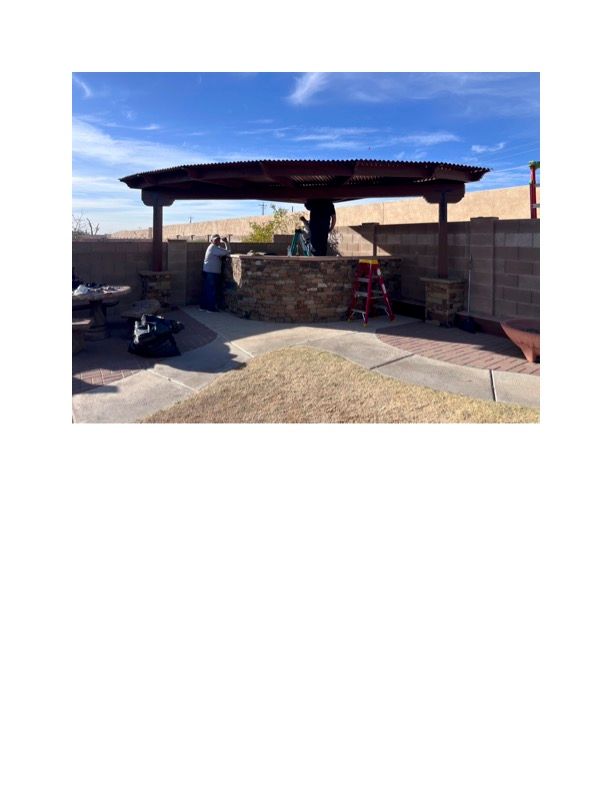 A man is standing under a pergola in a backyard.