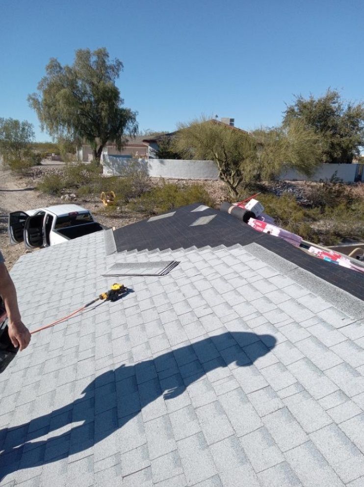 A man is measuring a roof with a tape measure