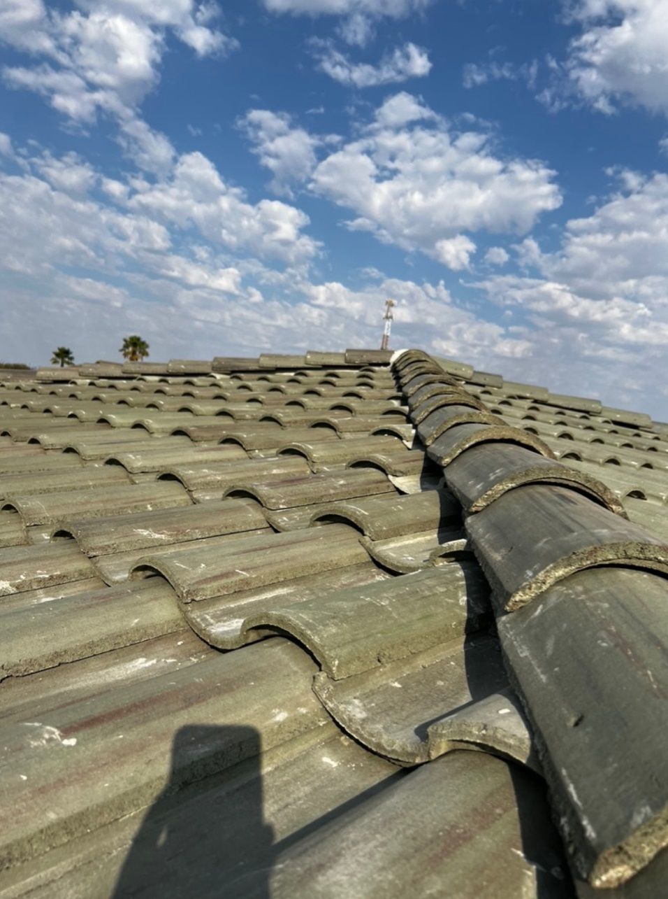 A roof with a blue sky and clouds in the background