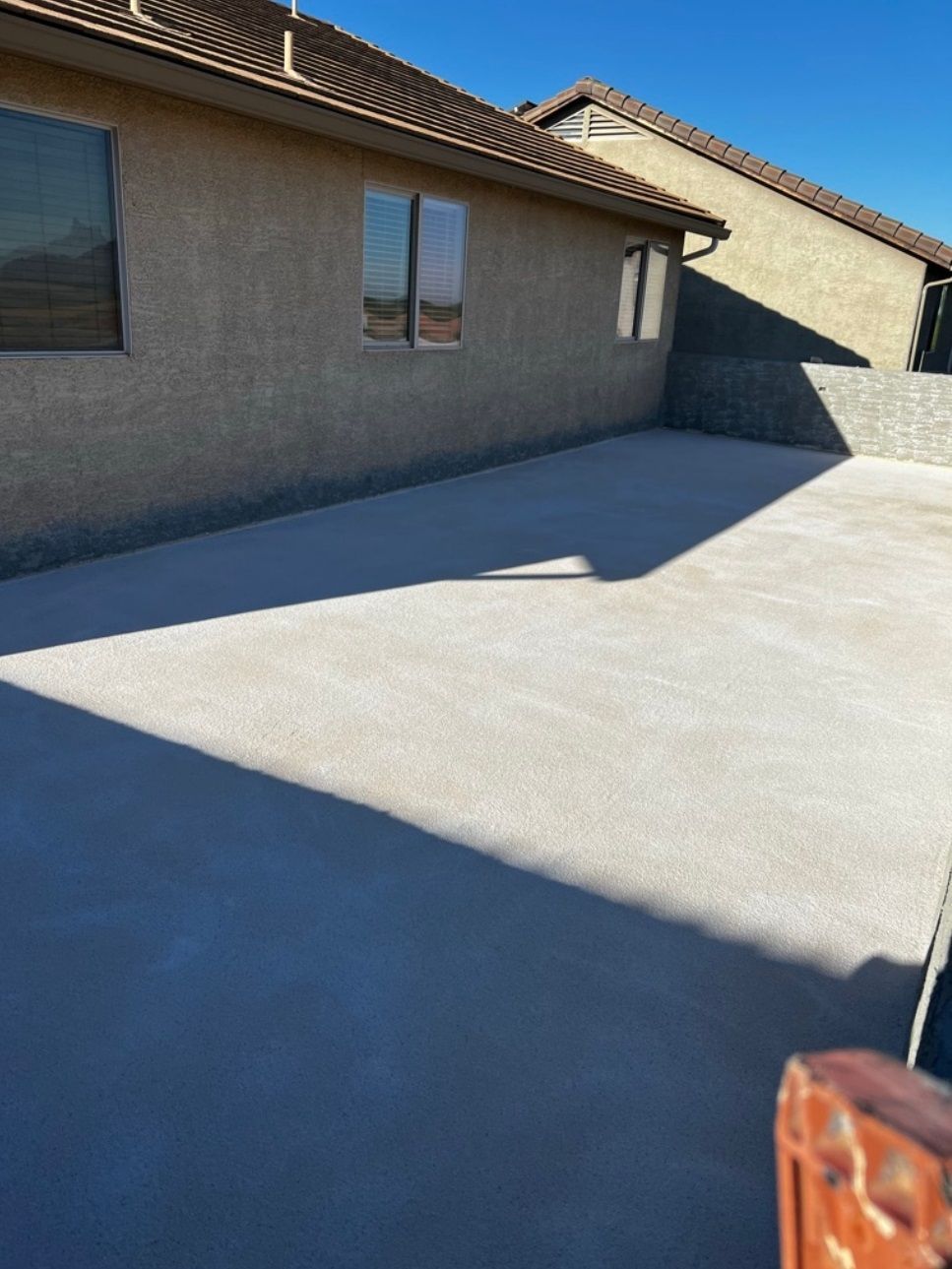 A concrete driveway in front of a house with a lot of windows.