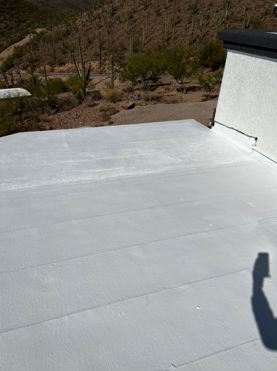A white roof with a shadow of a person on it.