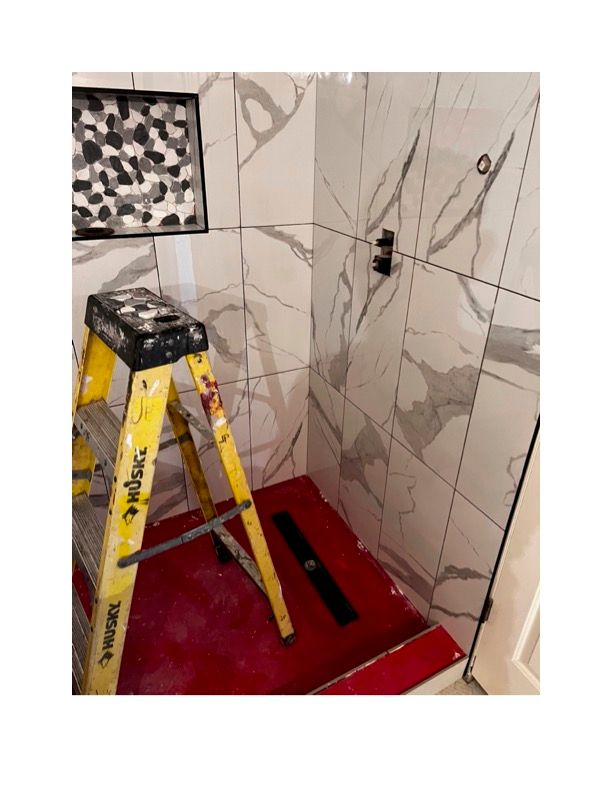 A yellow ladder is sitting in a bathroom next to a shower.