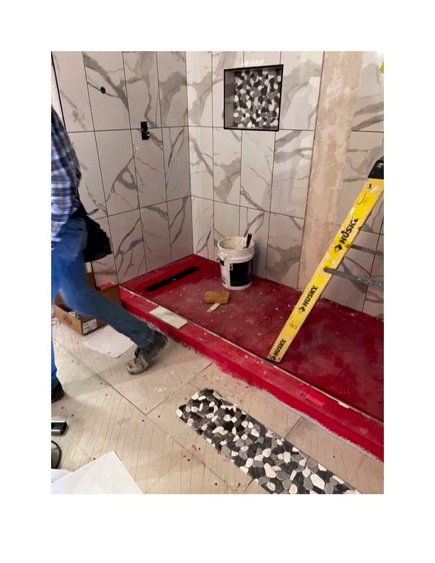 A man is standing next to a ladder in a bathroom under construction.