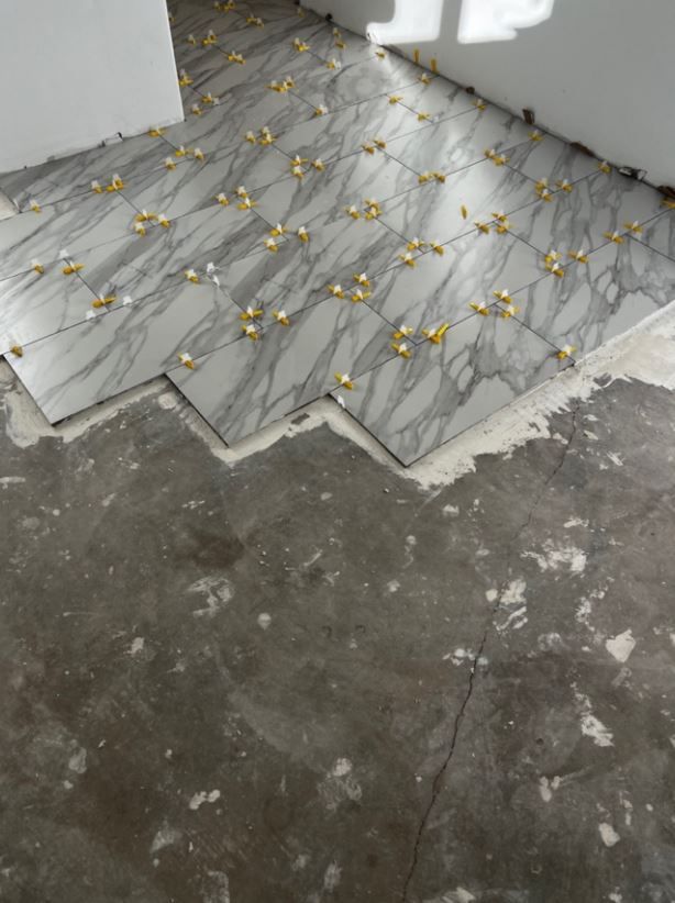 A tile floor is being installed in a room.