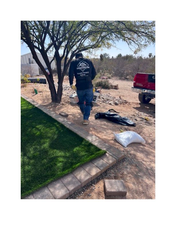 A man is walking across a lawn next to a truck. Turf is installed
