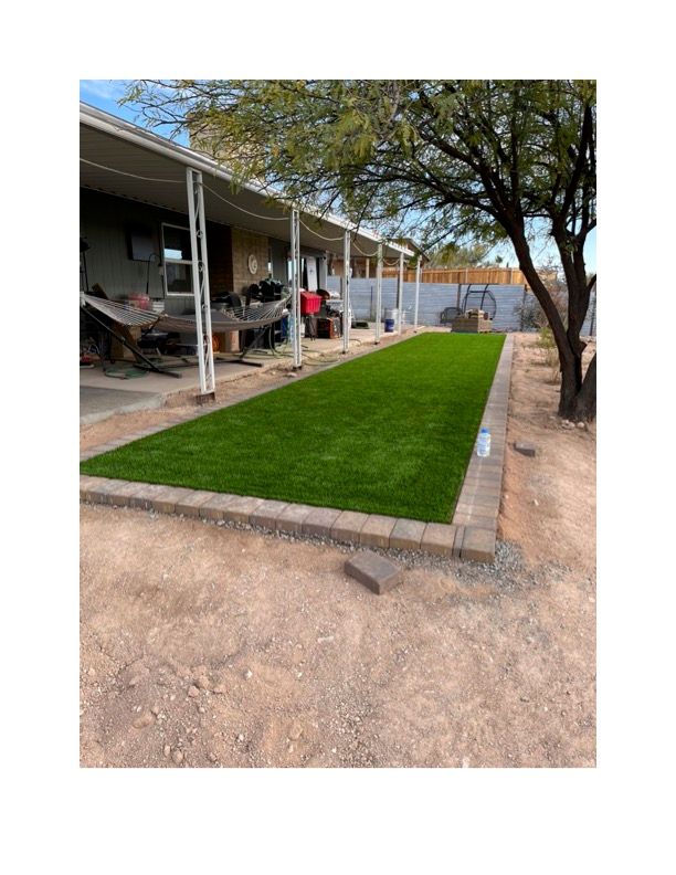 A house with a lush green lawn in front of it. Turf is installed