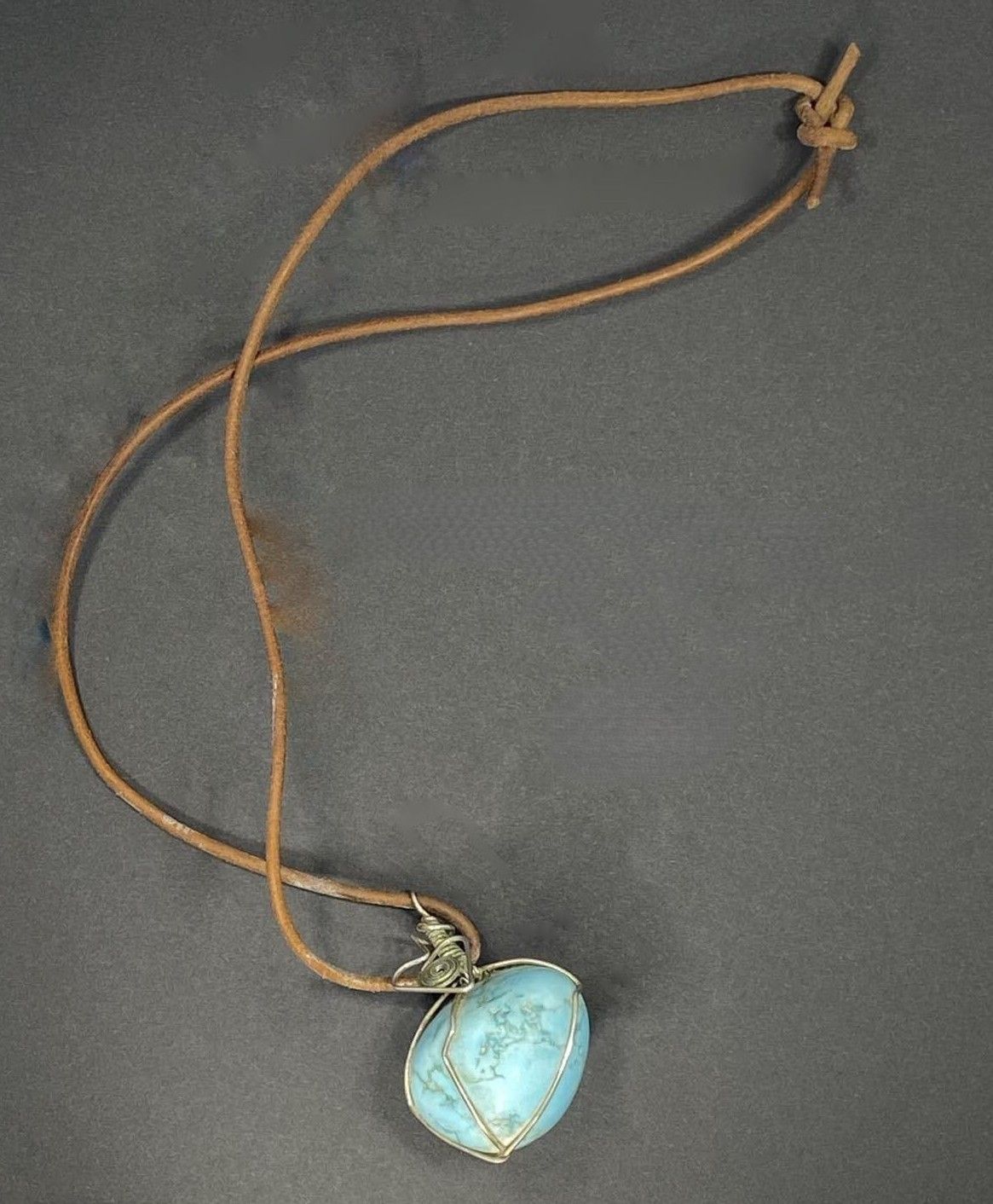 Turquoise tumbled stone on leather, wire wrapped.