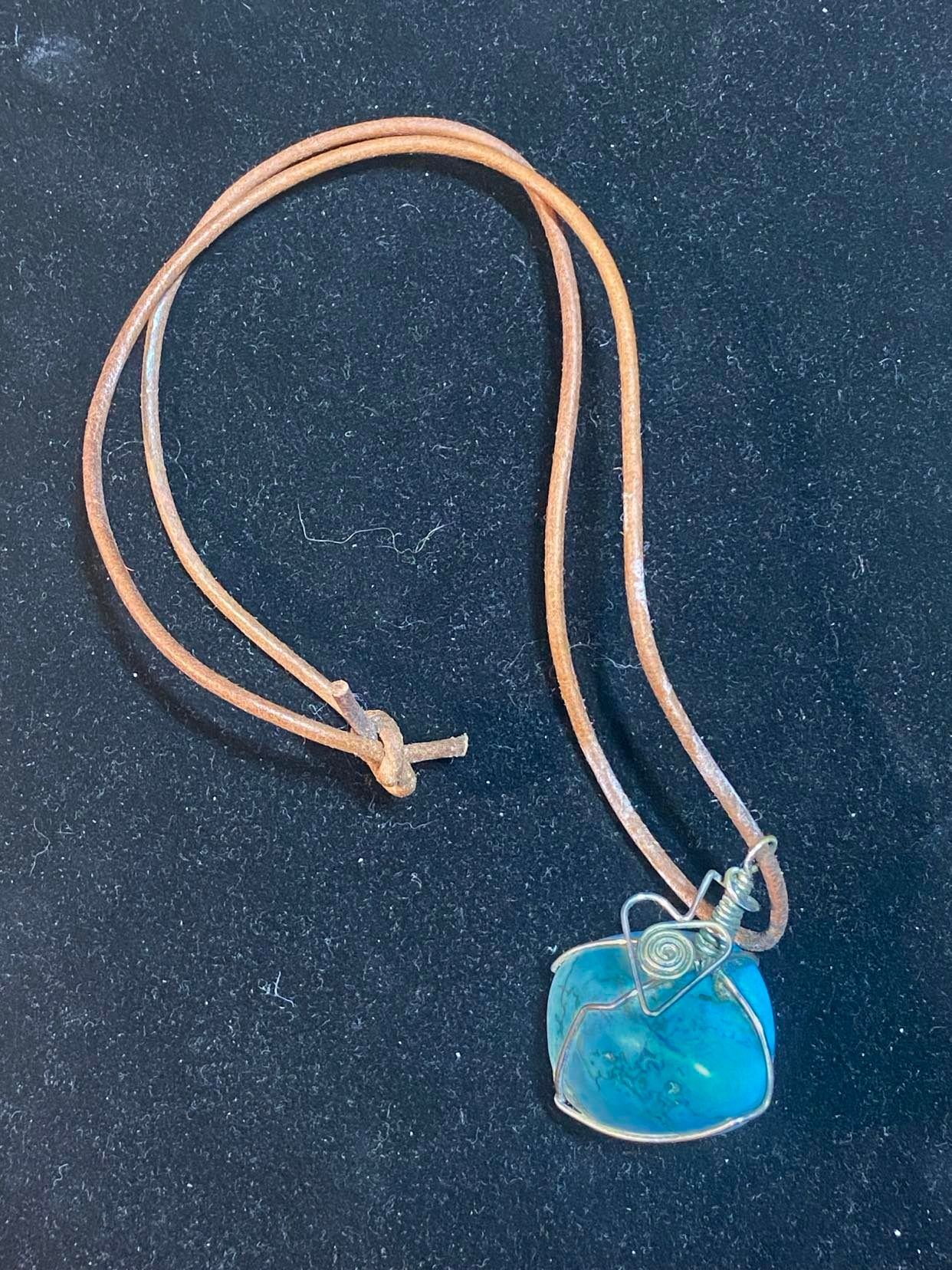 Turquoise tumbled stone on leather, wire wrapped.