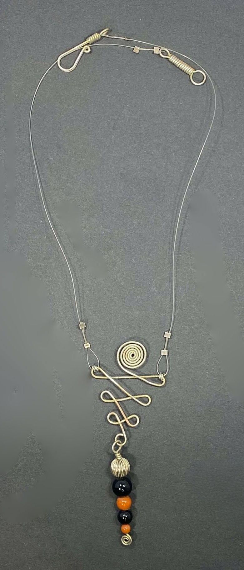 Red Jasper and Onyx in spiral wire design on illusion cord showing Hand made hook and link.