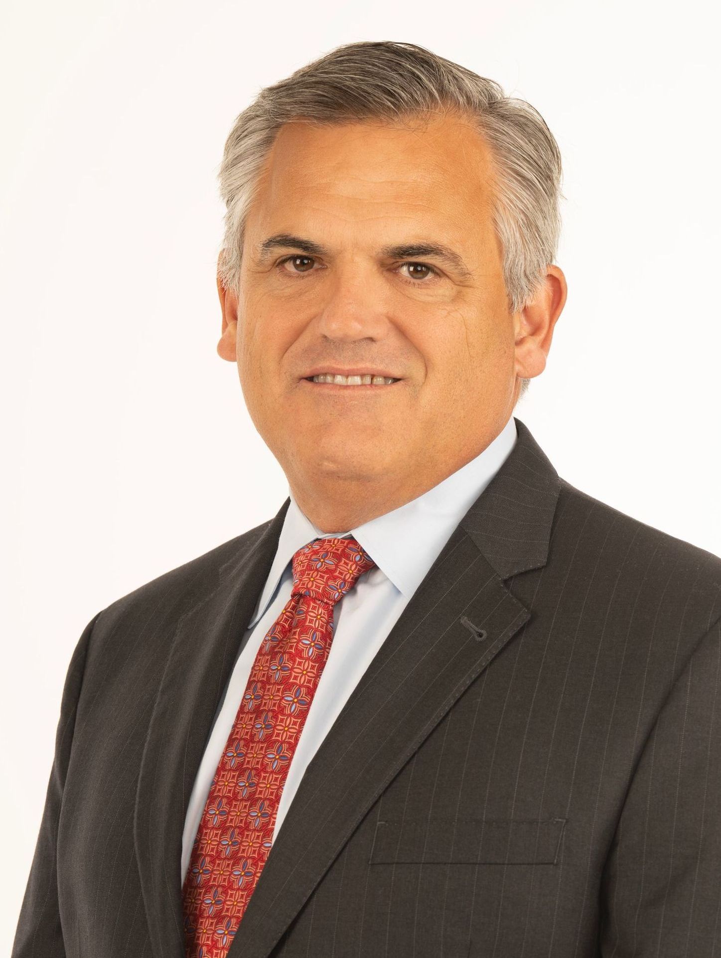 A man in a suit and tie is smiling for the camera.