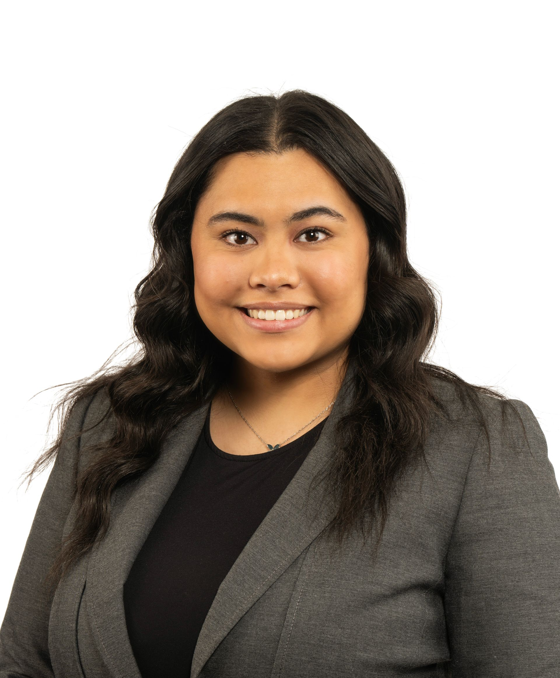 A woman in a black jacket and white shirt is smiling for the camera.
