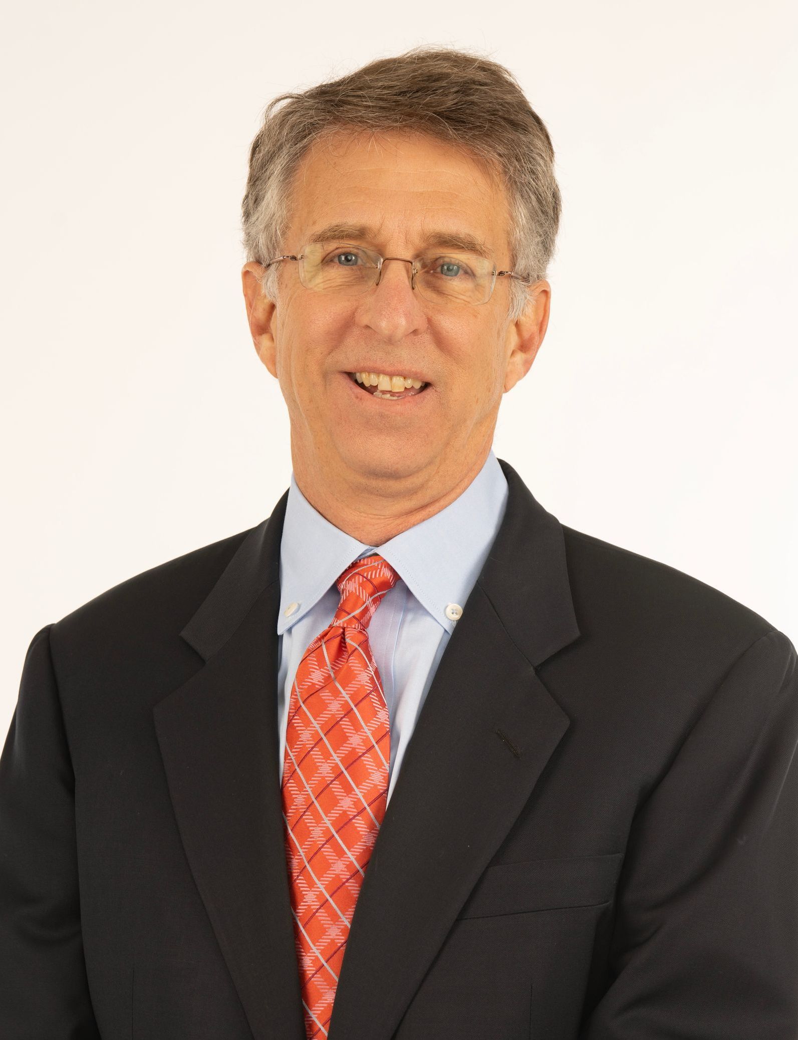 A man in a suit and tie is smiling for the camera