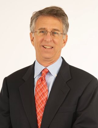 Attorney Michael J. Warshauer in a suit and tie is smiling for the camera