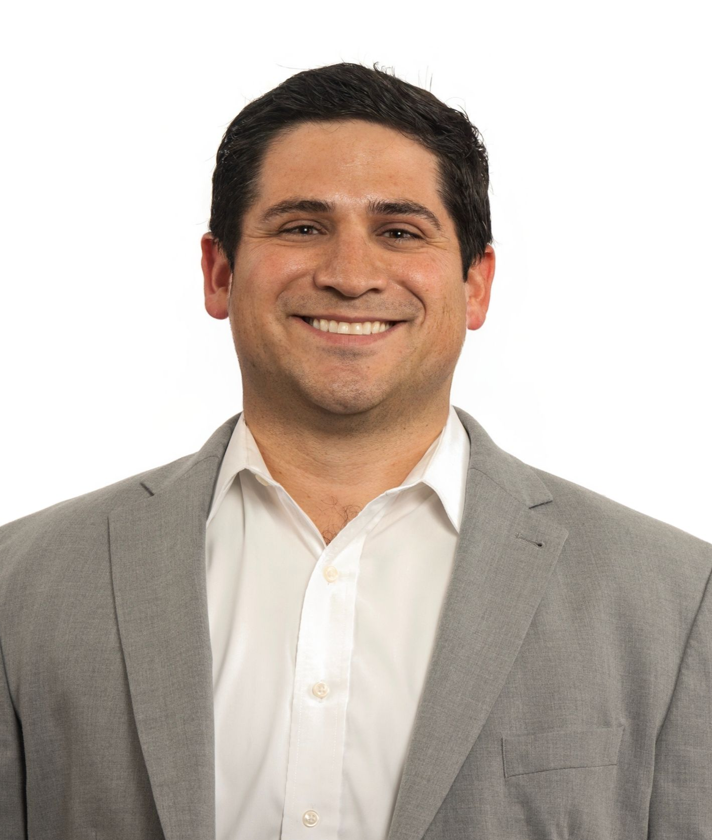 A woman is sitting in the back seat of a car holding a cell phone.