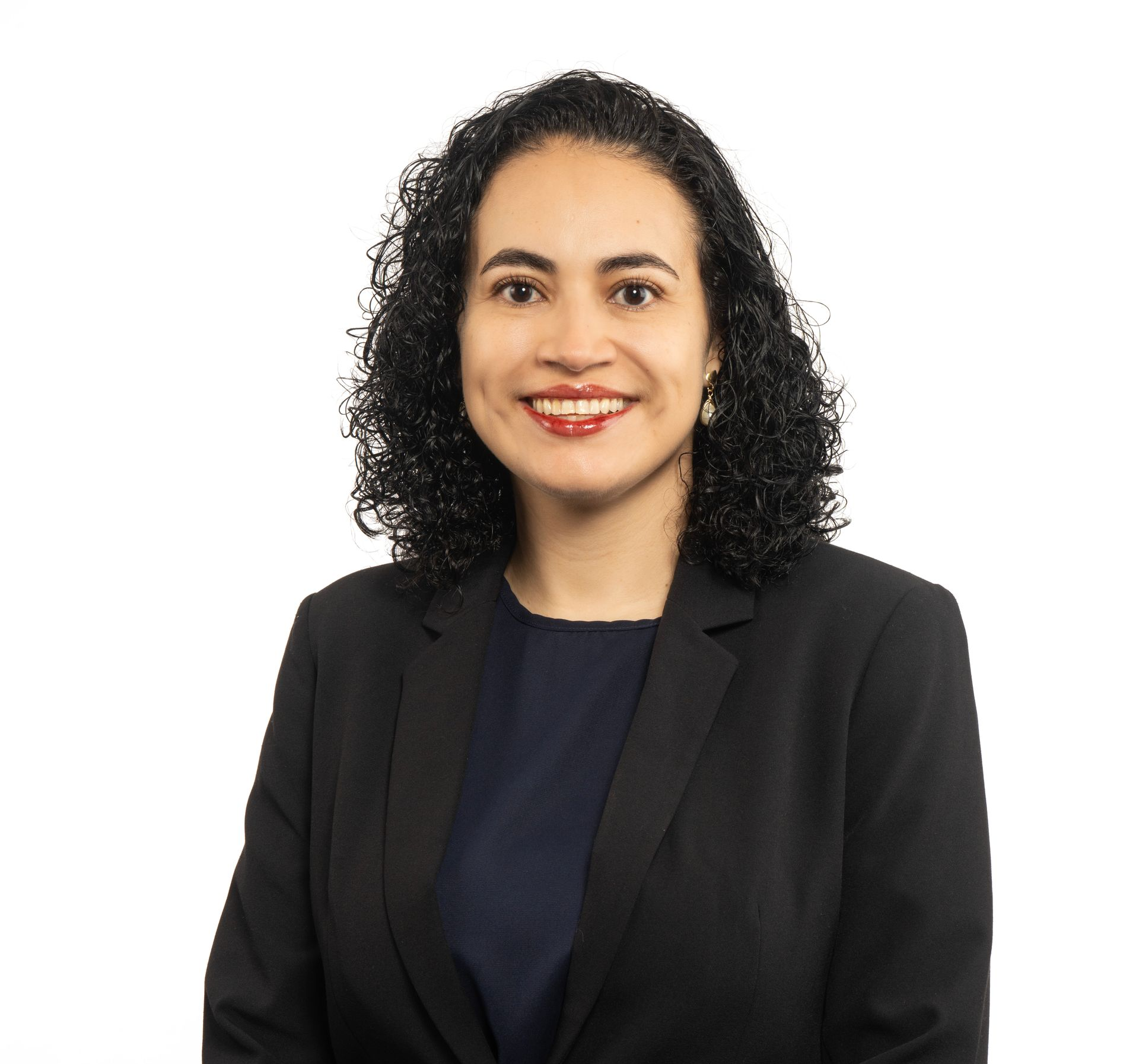 A woman in a black jacket and white shirt is smiling for the camera.