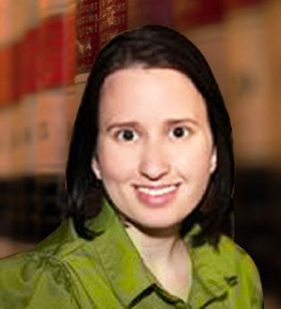 A woman in a green shirt is smiling for the camera.