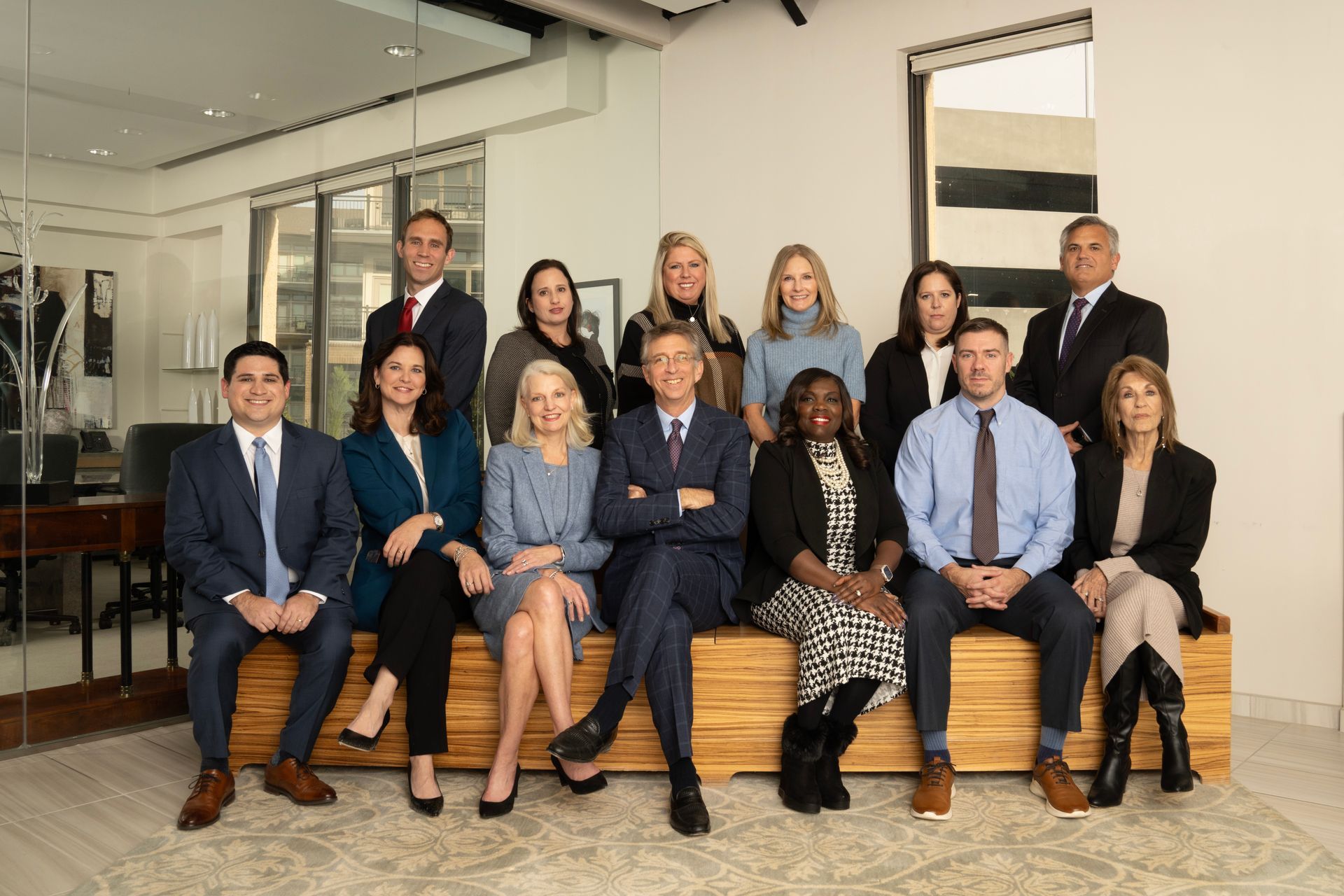 The Warshauer Woodward Atkins personal injury lawyers are posing for a picture while sitting on a bench.