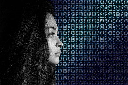 A black and white photo of a woman 's face surrounded by binary code.